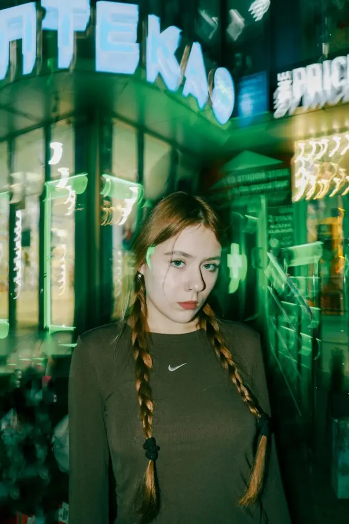 A woman with braids standing in front of a building